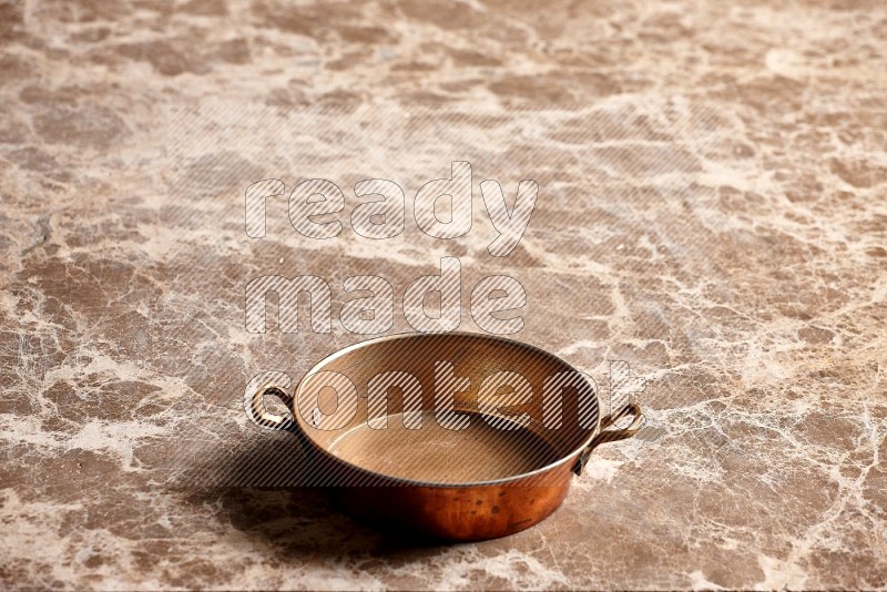 Small Copper Pan on Beige Marble Flooring, 45 degrees