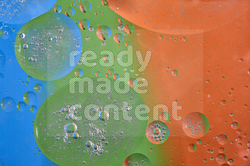 لقطات مقربة لفقاعات من الزيت على سطح الماء باللون البرتقالي والأخضر والأزرق