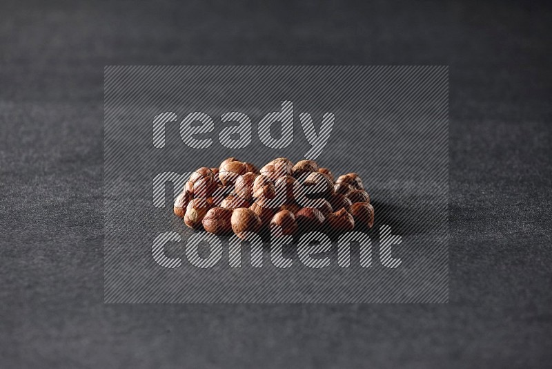 A bunch of peeled hazelnuts on a black background in different angles