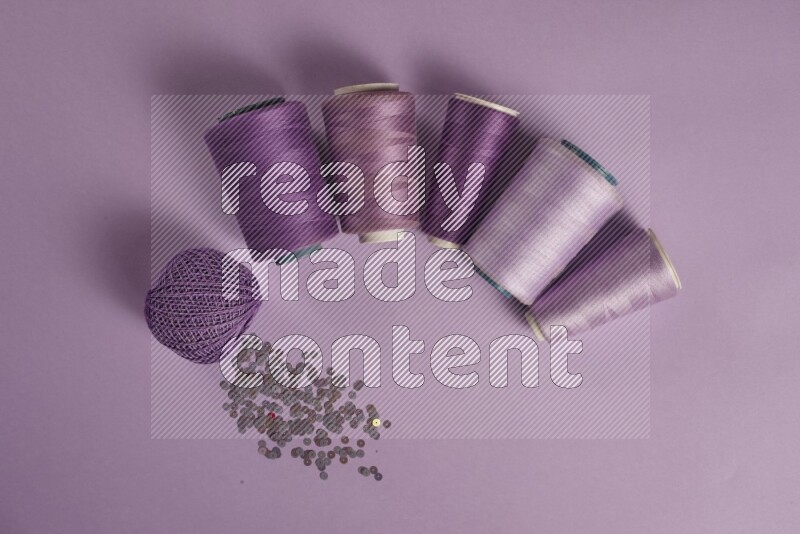 مجموعة من أدوات الخياطة والتفصيل أرجوانية اللون على خلفية أرجوانية