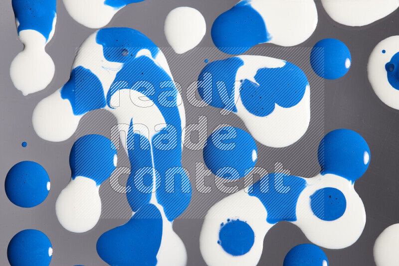 Close-ups of abstract white and blue paint droplets on the surface