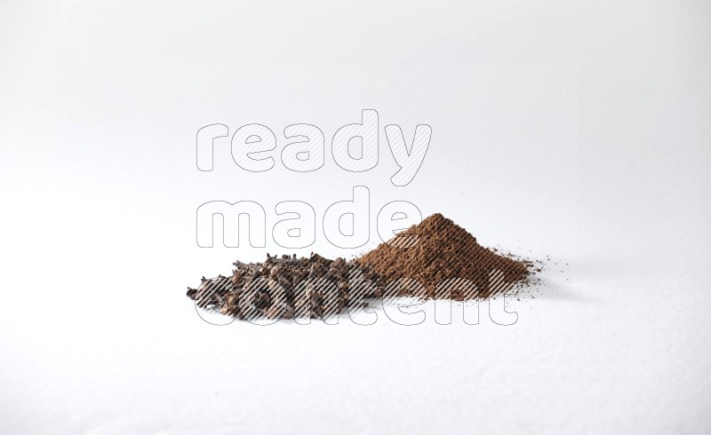 2 piles of cloves grains and cloves powder on a white flooring
