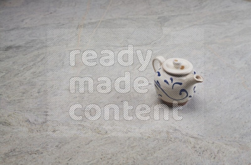 A pottery teapot on grey marble background