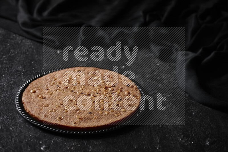 Basbousa in different plates in a dark setup