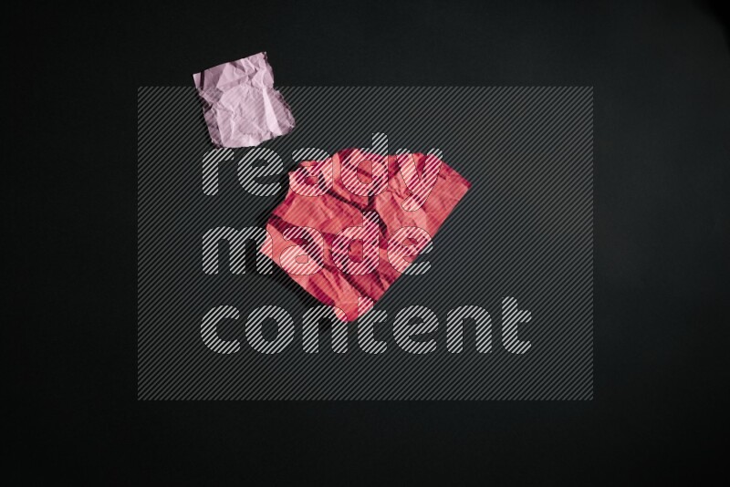 Crumpled multicolored paper on black background