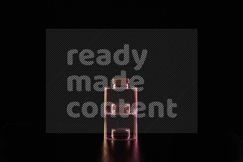 Glassware with rim light in red and yellow against black background