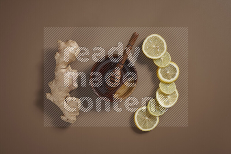 Fresh ginger root with different ingredients such as lemon, orange, honey, ground ginger on beige baackground