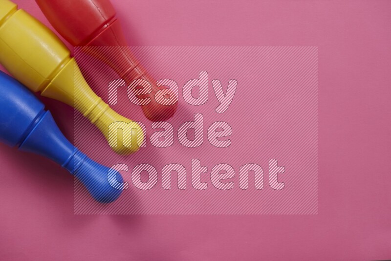 Multicolored plastic bowling pins on different colored backgrounds background (kids toys)