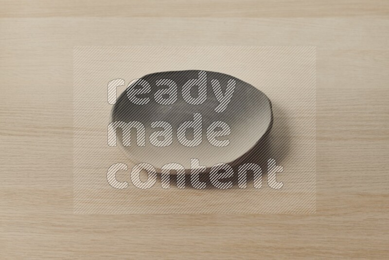 A multicolored pottery plate on light wooden background