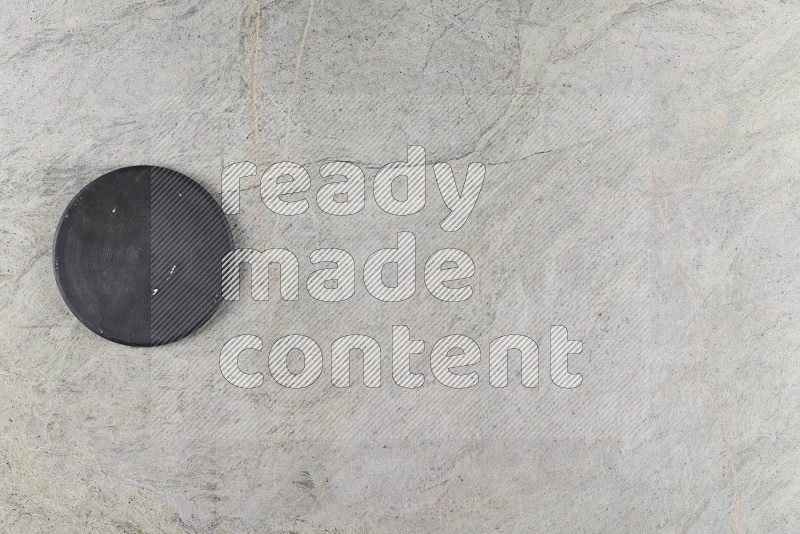 Top View Shot Of A Pottery Coaster On Grey Marble Flooring