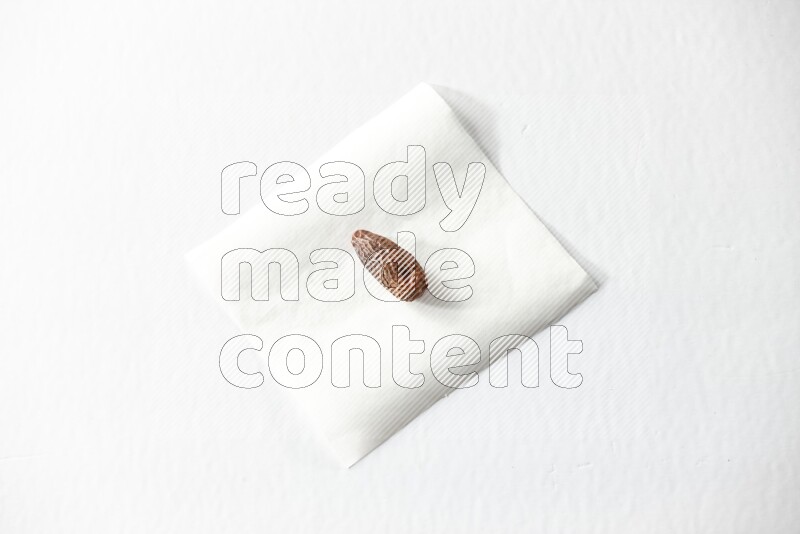 A dried date on a piece of paper on a white background in different angles