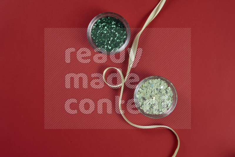 A green and red collection of sewing and tailoring tools arranged on a red background