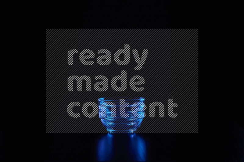 Glassware with rim light in blue against black background