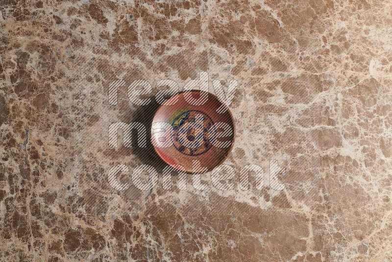 Top View Shot Of A Decorative Pottery Plate On beige Marble Flooring