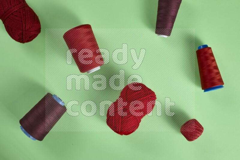 A red collection of sewing and tailoring tools arranged on a green background