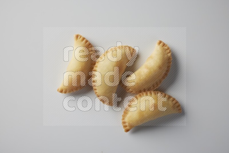Four fried sambosa from a top angle on a white background