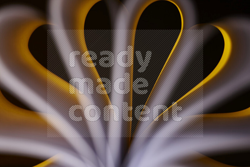 An abstract art piece displaying smooth curves in white and yellow gradients created by colored light
