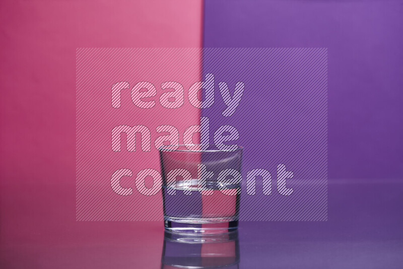 The image features a clear glassware filled with water set against pink and purple background