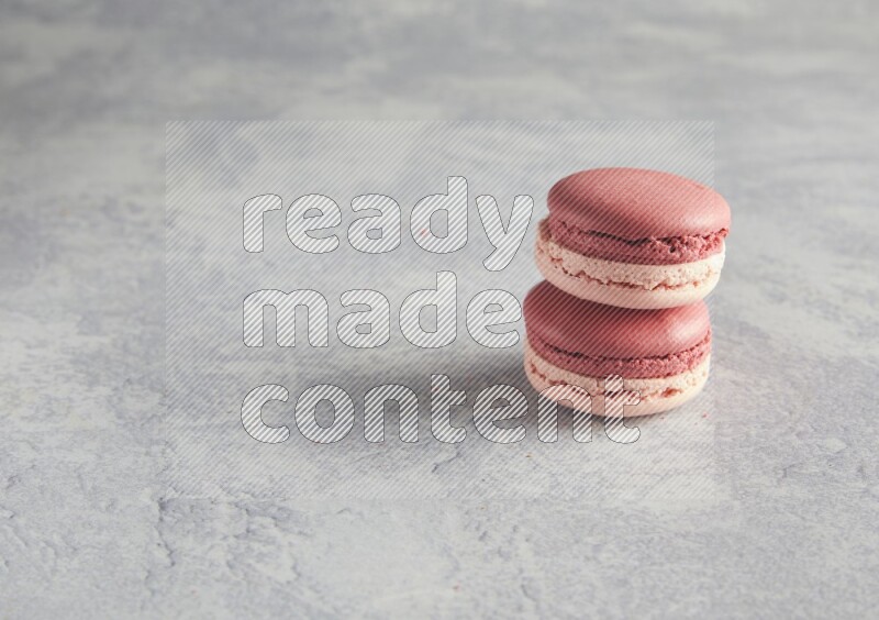 45º Shot of two Pink Litchi Raspberry macarons  on white  marble background