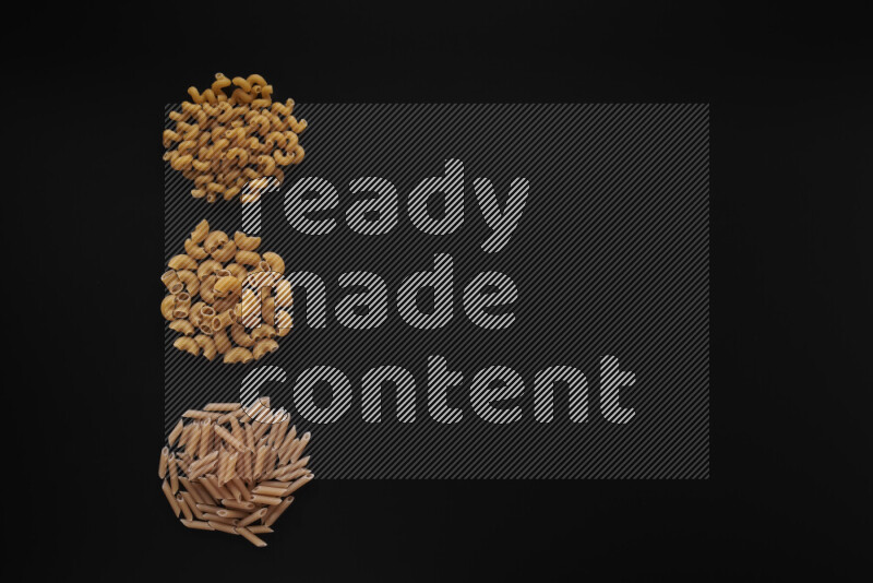 Different pasta types in 3 bunches on black background