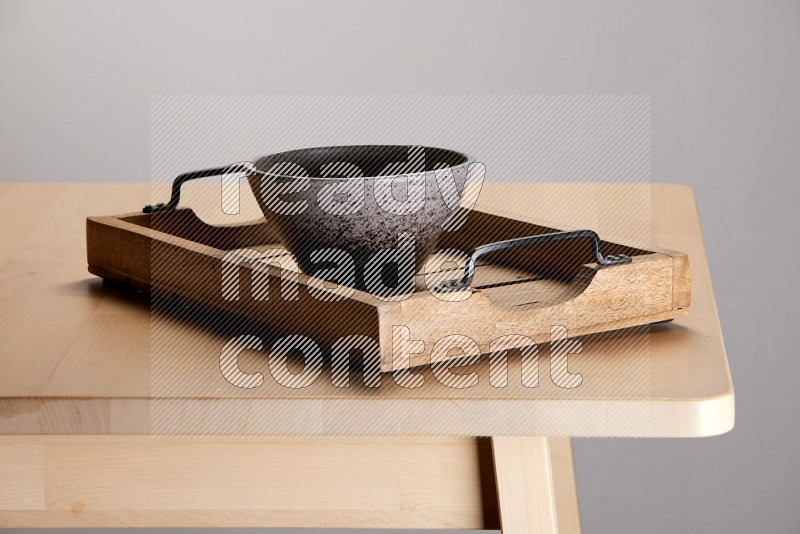multi colored  bowl on a light colored rectangular wooden tray with handles