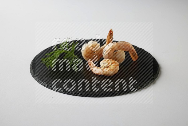 three grilled shrimp  on a black slate direct  on a white back ground