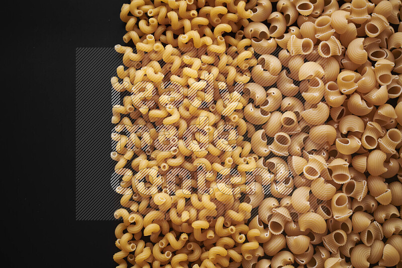 Different pasta types on black background