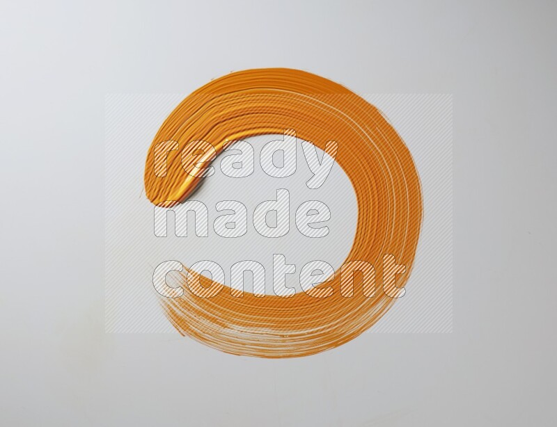 An orange circular painting brush stroke on white background