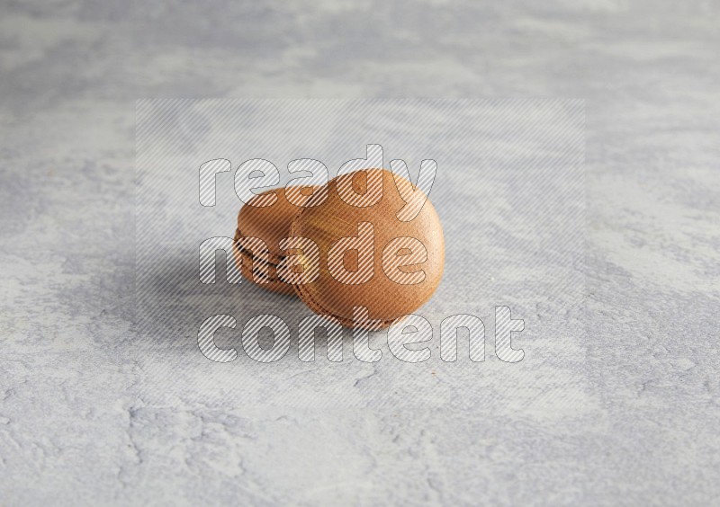 45º Shot of two Brown Coffee macarons  on white  marble background