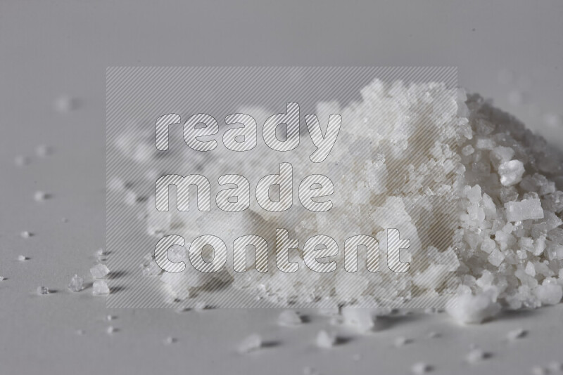 A bunch of coarse sea salt crystals on white background