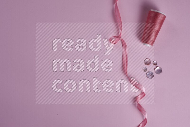 مجموعة من أدوات الخياطة والتفصيل زهرية اللون على خلفية زهرية