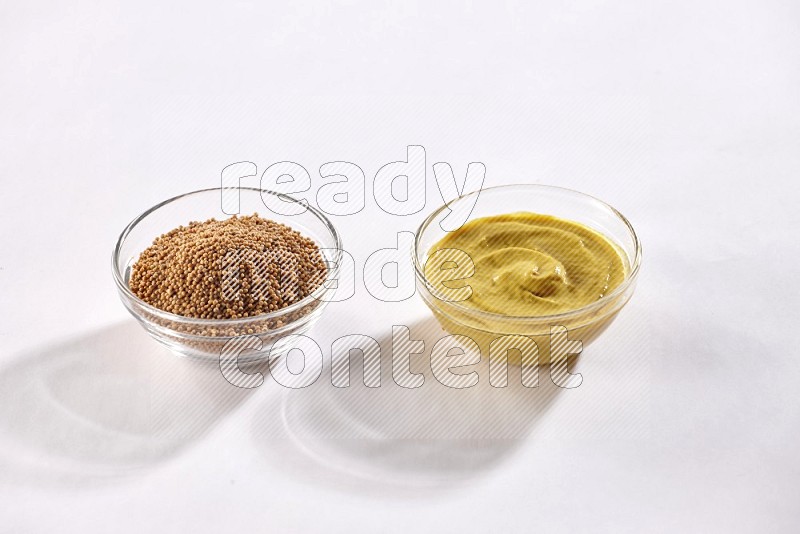 2 glass bowls, one full of mustard seeds and the other full of mustard paste on white flooring