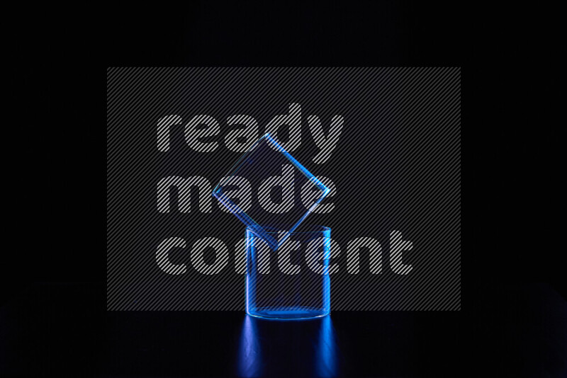 Glassware with rim light in blue against black background