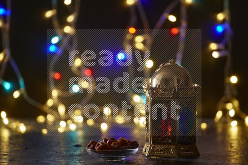 A traditional ramadan lantern surrounded by glowing fairy lights in a dark setup