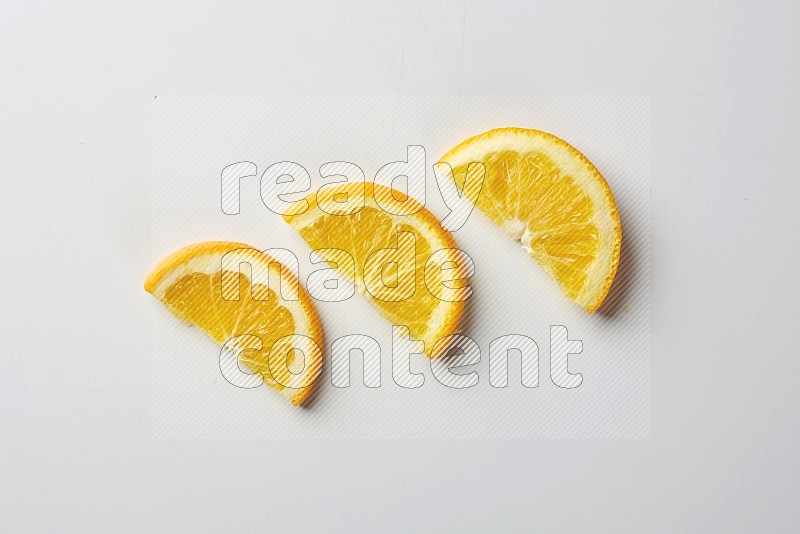 Three halves of an orange slices on white background