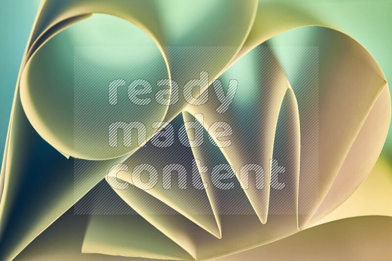 عرض فني لطيات الورق تخلق مزيج من الأشكال الهندسية، مضاءة بإضاءة ناعمة بدرجات اللون الأخضر والالوان الدافئة