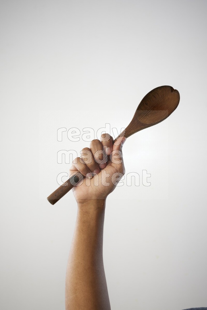 Male Hand Holding Wooden spoon on white background