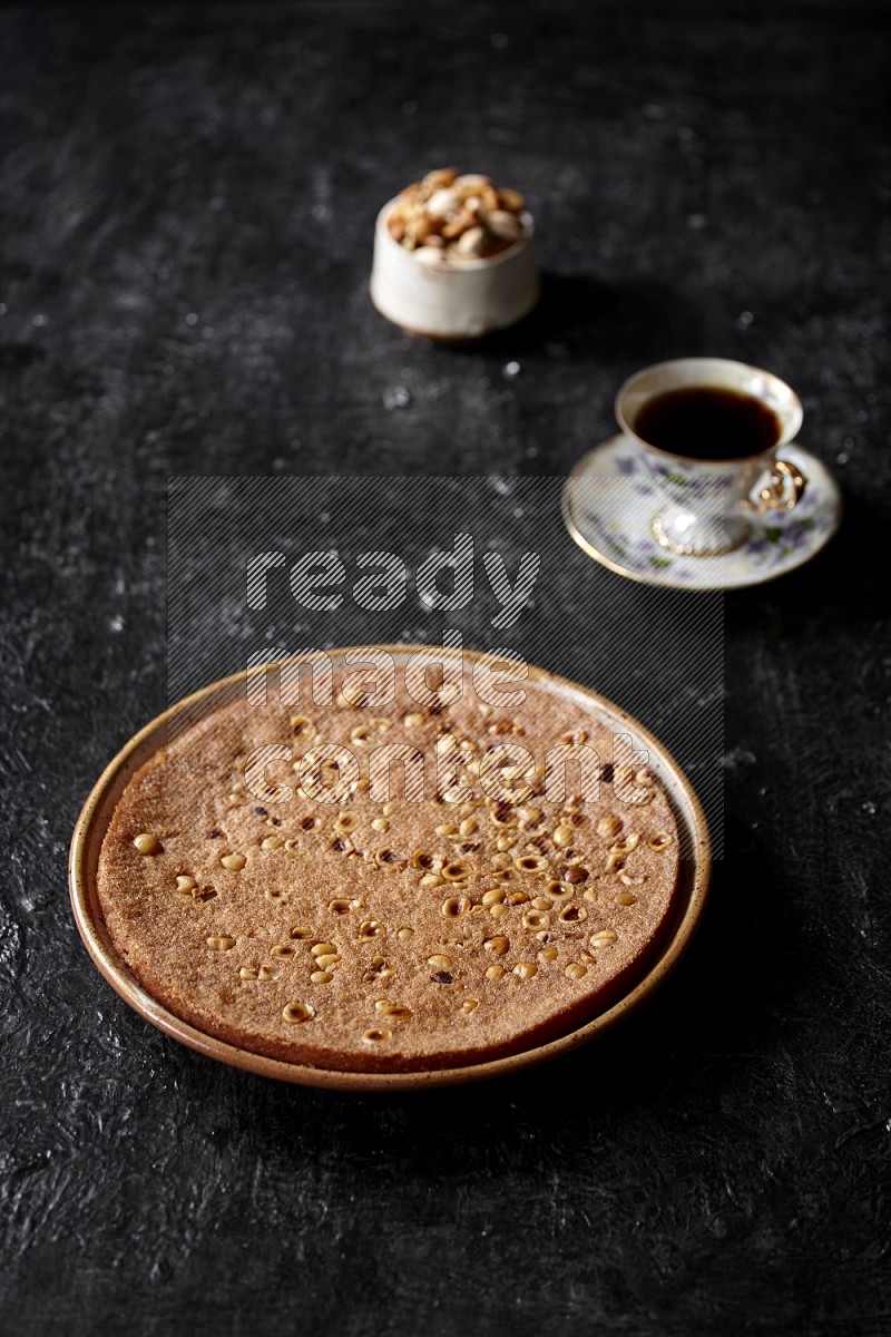 Basbousa with nuts and tea in a dark setup