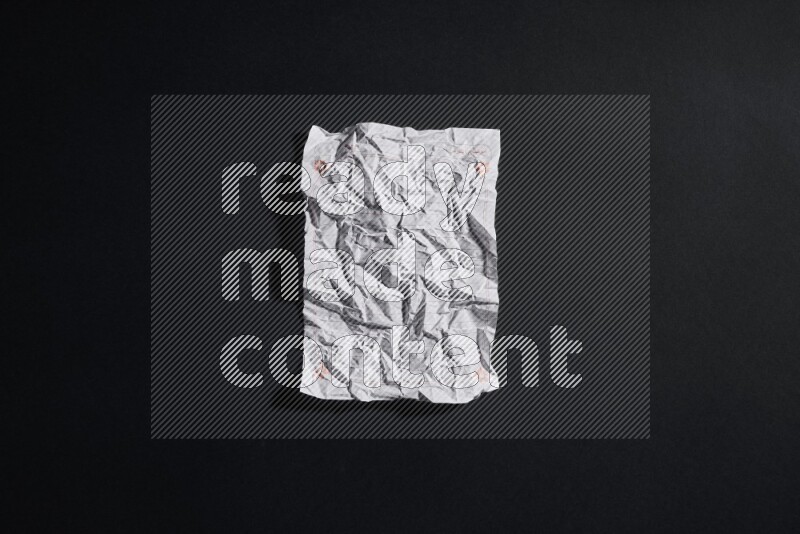 Crumpled notebook sheet on black background