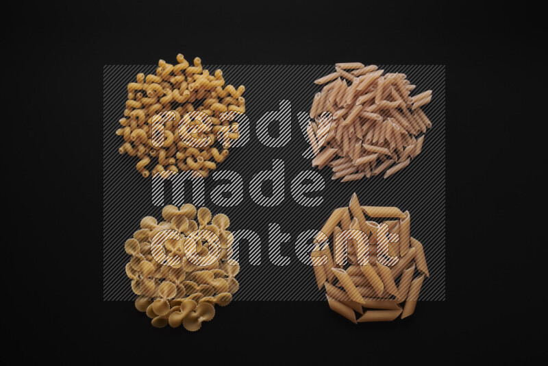 Different pasta types in bunches on black background