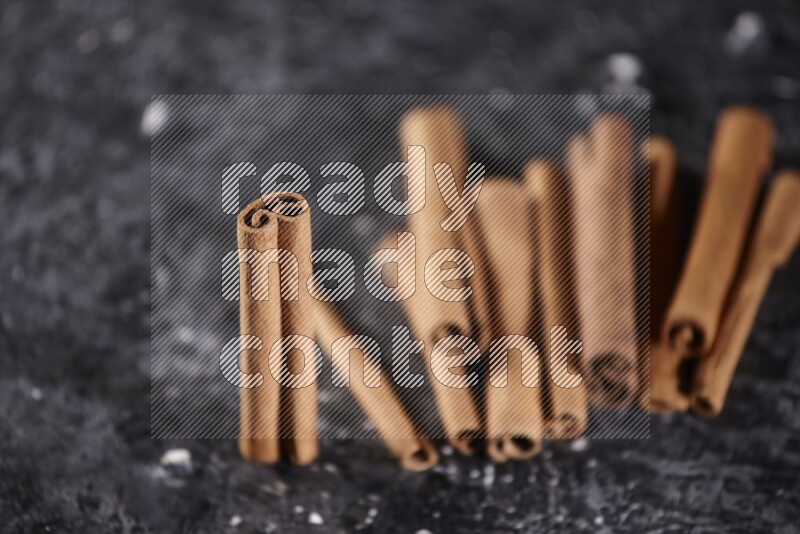 Cinnamon sticks on a textured black background
