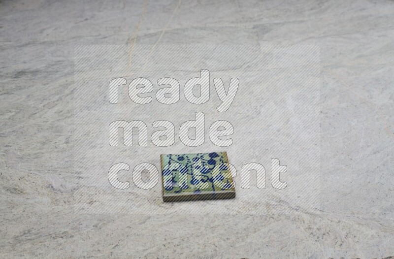 Top view shot of a pottery coaster\ tile on beige marble flooring