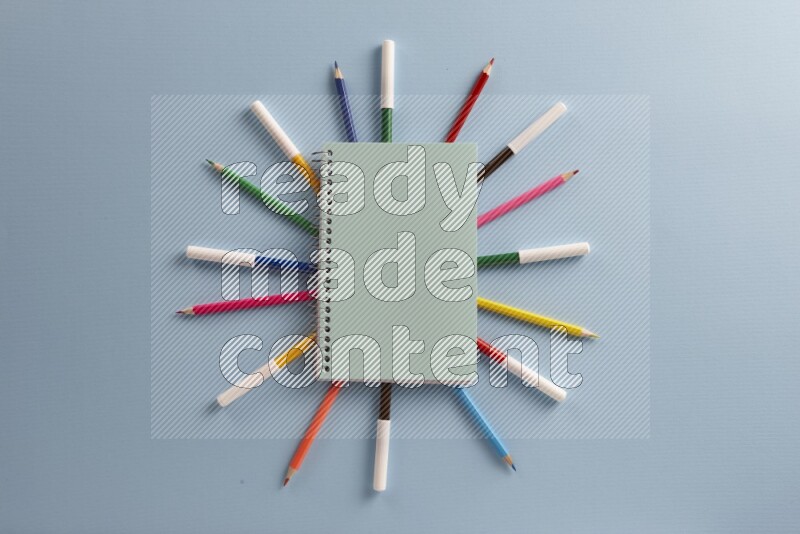 دفتر ملاحظات أزرق مع مستلزمات مدرسية مختلفة على خلفية زرقاء