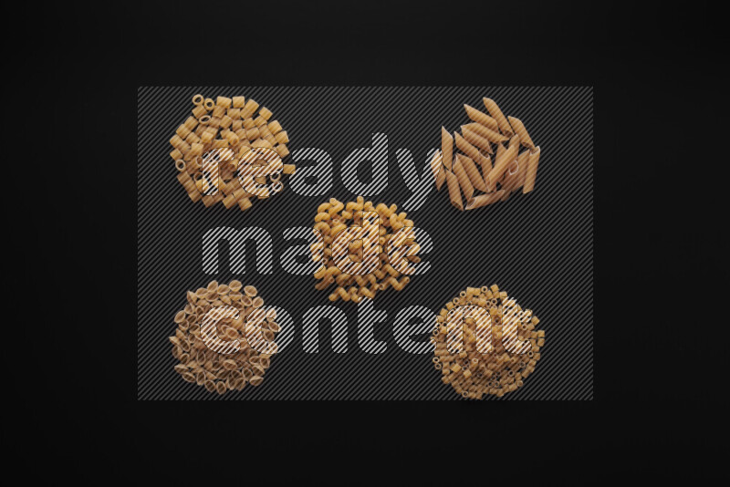 Different pasta types in bunches on black background