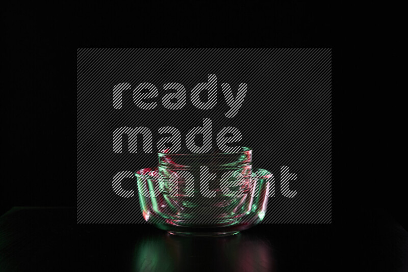 Glassware with rim light in red and green against black background