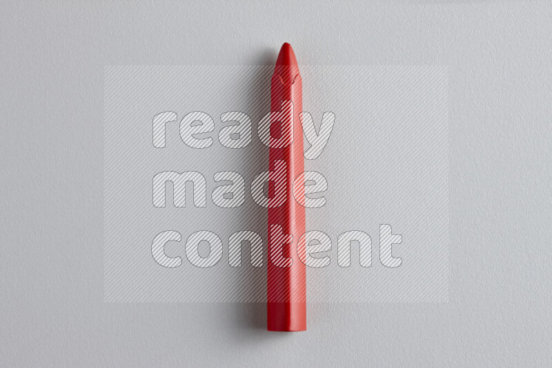 A close-up showing a single wax crayon on grey background