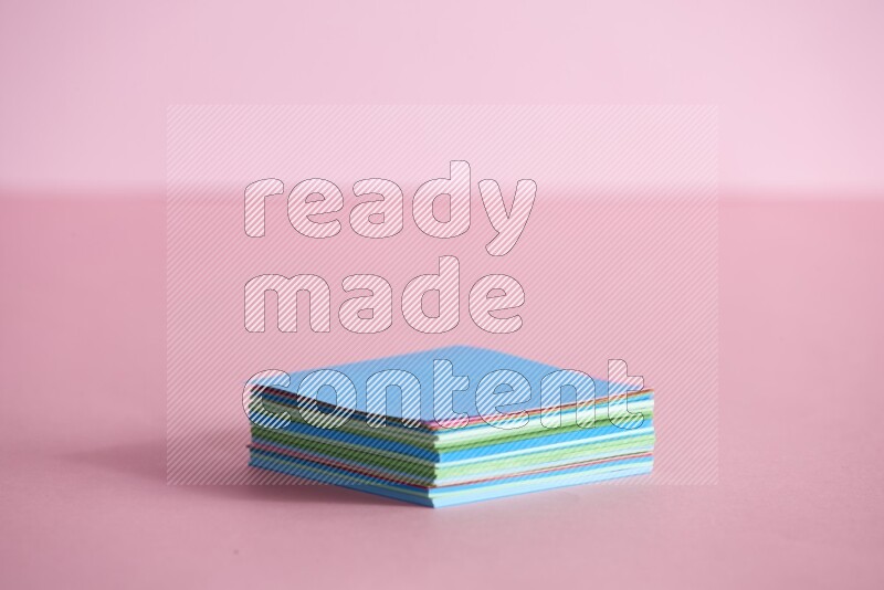 Stacked multicolored sticky notes on rose background