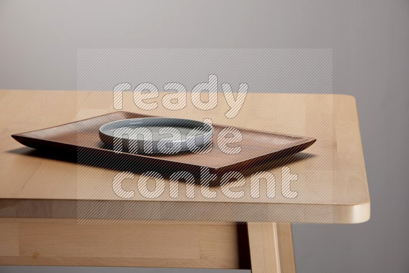 light blue plate placed on a wooden tray with  on the edge of wooden table