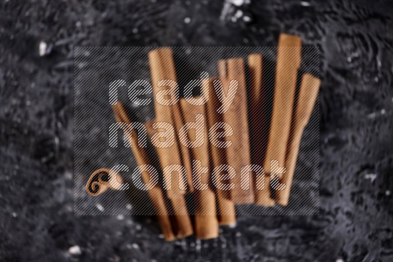 Cinnamon sticks on a textured black background
