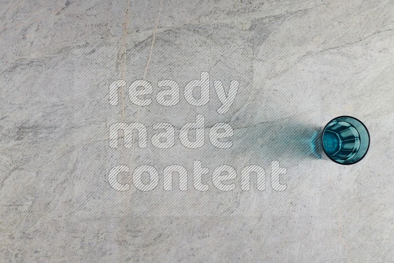 Top View Shot Of A Turquoise Glass On Grey Marble Flooring